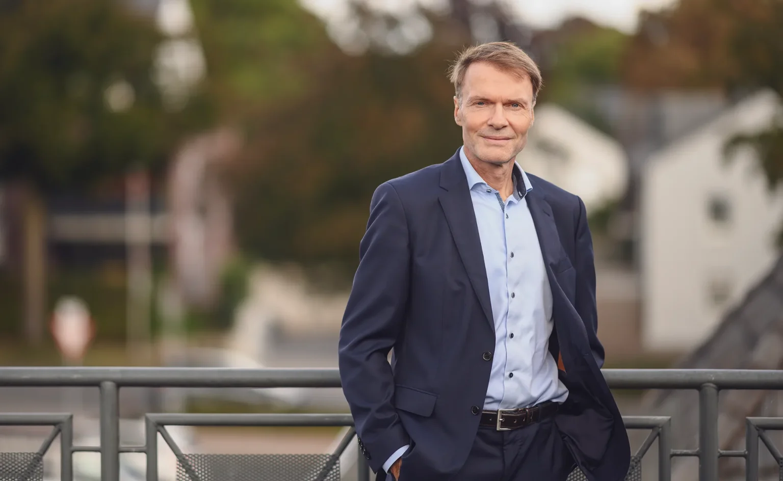 Im Vordergrund steht Andreas Lutze von der Kanzlei Lutze Rechtsanwälte auf einer Außenterrasse.